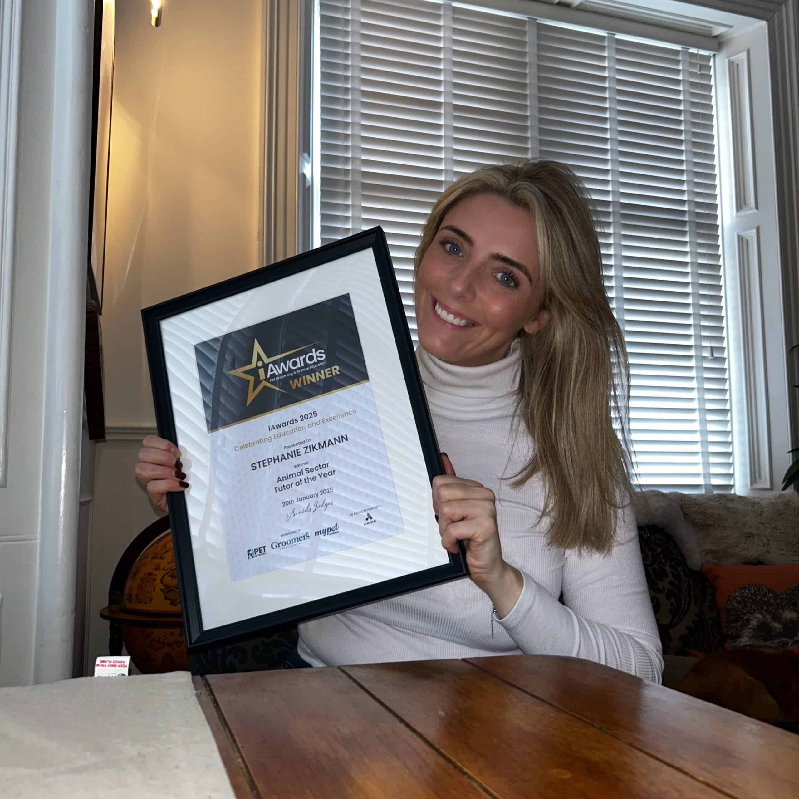 Stephanie Zikmann proudly holds up her award, 'Best Animal Sector Tutor of the Year 2025'